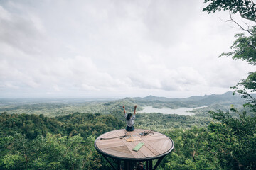 tourist sits at viewpoint at Kalibiru National Park, Indonesia