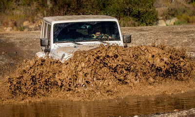 A  4x4 vehicle crossing stream creating wave of mud in Trabucco Canyon California © F Armstrong Photo