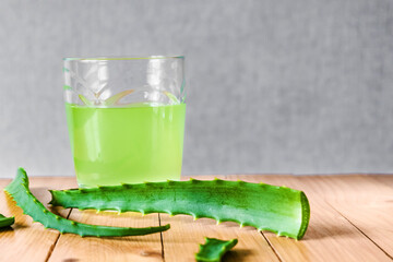 Aloe Vera juice on a wooden background. Natural juice and aloe leaves. Copy space