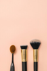 Three makeup brushes in a vertically positioned image.