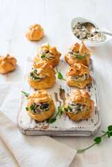 Profiteroles stuffed with cream cheese and mushrooms on white wooden background