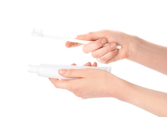 Female hands with toothbrush and paste on white background