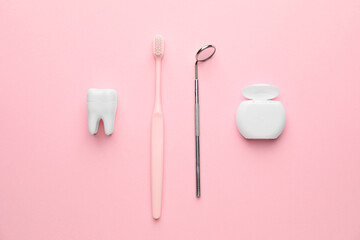 Dental mirror with toothbrush and floss on color background