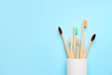 Holder with toothbrushes on color background