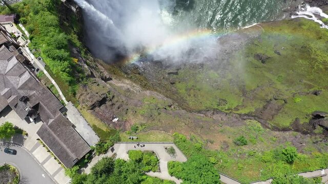 Aerial / drone footage of a rainbow over Snoqualmie Falls by Issaquah and North Bend near Seattle, Washington during the COVID-19 pandemic closure