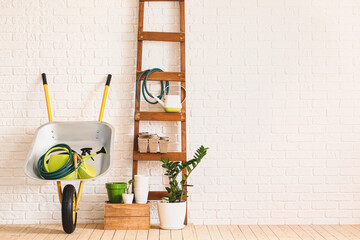 Set of gardening supplies near brick wall