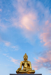 Golden big buddha statue and blue sky background in Thailand