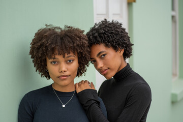 Portrait of two stylish sisters with curly hair