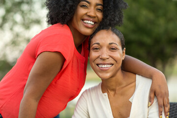 African American mother hugging her adult daughter.
