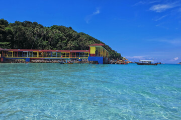 Beautiful landscape with a water taxi approaching a colourful jetty in Perhentian Island