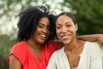 African American mother hugging her adult daughter. - Powered by Adobe