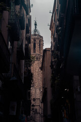 Quite street of Barcelona with a tower and sky and clouds in the background