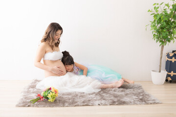 Obraz na płótnie Canvas ドレスを着た妊婦さんと女の子のポートレート