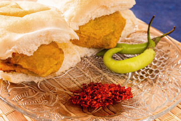 Traditional Indian snack. Vada Pav with garlic chutney and green chilies.
