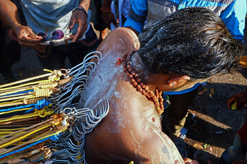 High angle shot of a Kavadi bearear back after completed kavadi pearcing process on Thaipusam day with soft focus effect due to large aperture.