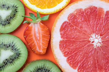 Cut kiwi, grapefruit, strawberry and orange. Fruits summer background. Citruses bright texture, tropical colorful pattern.