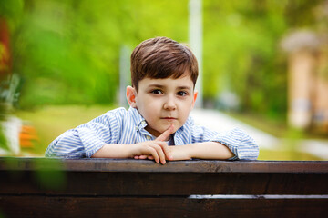 Large portrait of a thoughtful boy in a Park. Looks at the camera.