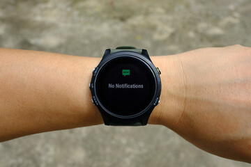 Fototapeta premium No notification status on modern round-faced GPS multisport digital smartwatch on left hand wrist, selective focus.