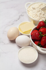 ingredients for baking strawberry muffins place for text.