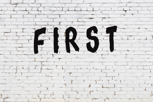 Word first painted on white brick wall