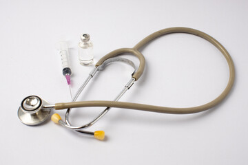 Medical equipment, stethoscope, syringe, ampoules on a white background.