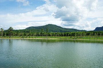 Landscape of natural lake with green mountain range and cloudy blue sky