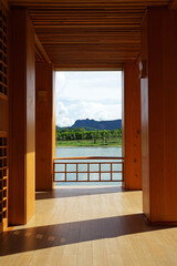 View from wooden balcony terrace of natural lake landscape with green mountain range