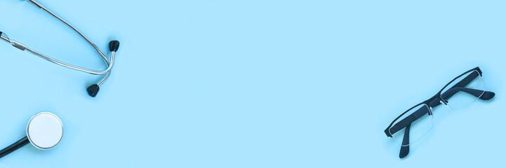 stethoscope and eyeglass lying on a blue background. The concept of medical equipment instrument.