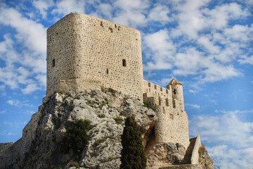 One of the oldest towns in Spain, Olvera Castle (Castillo Olvera) as seen from the Plaza de Iglesia (Church Square) with blues sky and stormy weather.