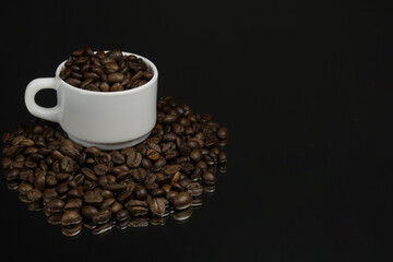 White mug with coffee grains sprinkled with coffee grains on a background