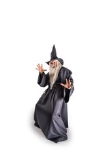 A stern grey-haired bearded wizard in a gray cassock and a cap is practicing sorcery and doing magic against a light background.