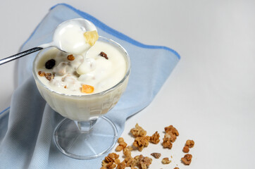 Ready to eat yogurt in a beautiful glass bowl with the addition of granola.