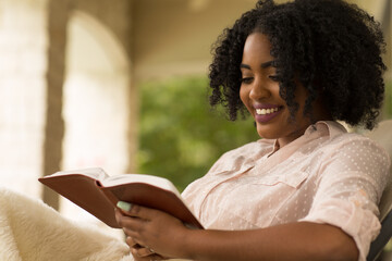 African American woman studing and reading the Bible.