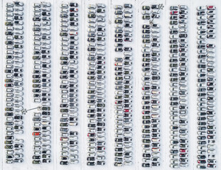 Aerial view of new cars covered in snow lined up outside an automobile factory