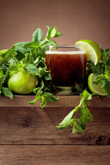 Carbonated drink with limes and mint on a old wooden table.