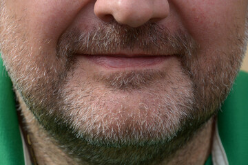 face to face shot of three-day full beard of middle aged man with narrow lips