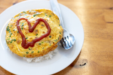 
Omelette on a white plate with red heart-shaped sauce