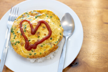 
Omelette on a white plate with red heart-shaped sauce