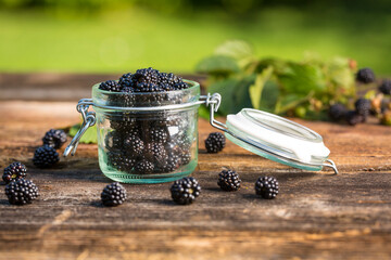 Tasty blackberry jam and fresh berries, on rustic wooden background