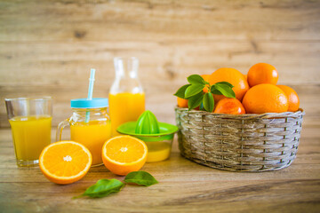 Squeezed orange juice and fresh oranges fruits on rustic wooden table