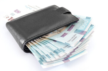 1000 hryvnia in a black men's wallet on a white background. Close-up.