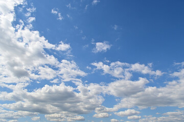 White fluffy clouds on the blue sky, nature background.