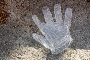 Discarded medical glove on the street. Pollution problems.