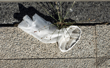 Discarded medical glove on the street. Pollution problems.