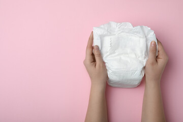 Woman with diaper on pink background, closeup. Space for text