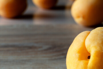 four apricots in backlight on a wooden background