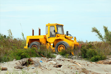 bulldozer on the sea shore to move the sand and clean up before