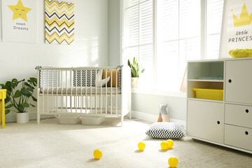 Cute baby room interior with crib and big window