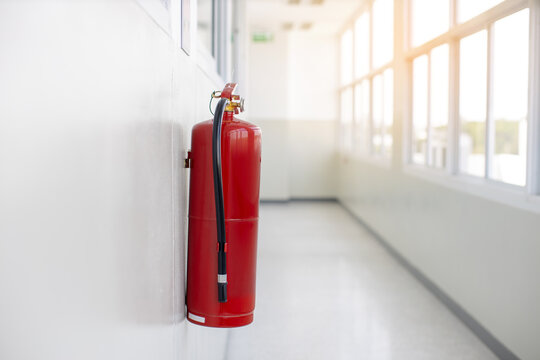 Fire extinguisher in empty white corridor