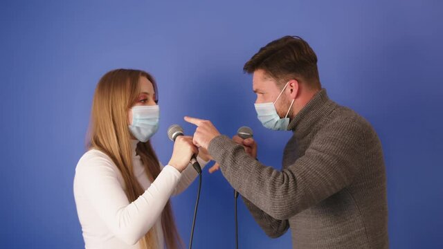 Young couple singing wearing medical masks. Isolated of blue